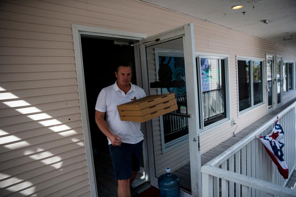 Corban Chesnut, the owner of Captiva Island Pizza on Captiva Island delivers pizza to local businesses on Andy Rosse Lane on Wednesday, Jan. 4, 2023. His business is one one of the few business that are back open after Hurricane Ian. 