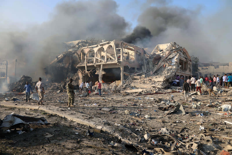 Sur les lieux de l'une des déflagrations à Mogadiscio. L'explosion de deux voitures piégées à Mogadiscio samedi a fait au moins 22 morts et plusieurs blessés, rapporte la police. /Photo prise le 14 octobre 2017/REUTERS/Feisal Omar