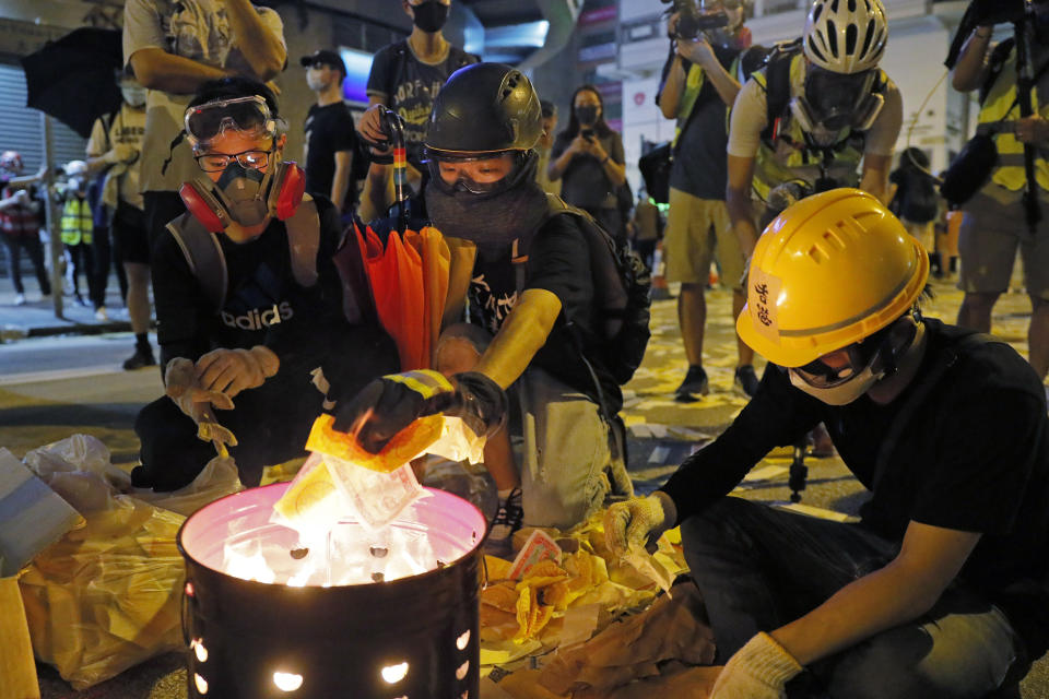 Protesters burn paper money to pay their respects for protesters who were injured on Aug 31 outside Prince Edward station in Hong Kong on Friday, Sept. 6, 2019. The ratings agency Fitch on Friday cut Hong Kong's credit rating and warned that conflict with anti-government protesters was hurting the image of its business climate. (AP Photo/Kin Cheung)