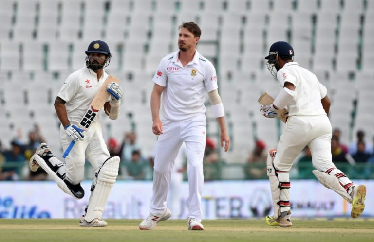 South Africa's Dale Steyn (C) looks on as India's Cheteshwar Pujara (R) and teammate Murali Vijay (L) run between the wickets during play on the first day of the first Test in Mohali on November 5, 2015