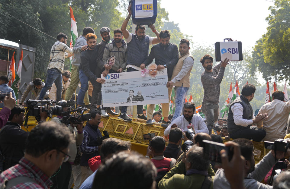 Members of opposition Congress party, demanding an investigation into allegations of fraud and stock manipulation by India's Adani Group stand atop a police barricade during a protest in New Delhi, India, Monday, Feb.6, 2023. The Congress party urged people to protest, adding to pressure on Prime Minister Narendra Modi to respond to a massive sell-off of shares in Adani Group companies after a U.S.-based short-selling firm, Hindenburg Research, accused them of various fraudulent practices. The Adani group has denied any wrongdoing. (AP Photo/Manish Swarup)