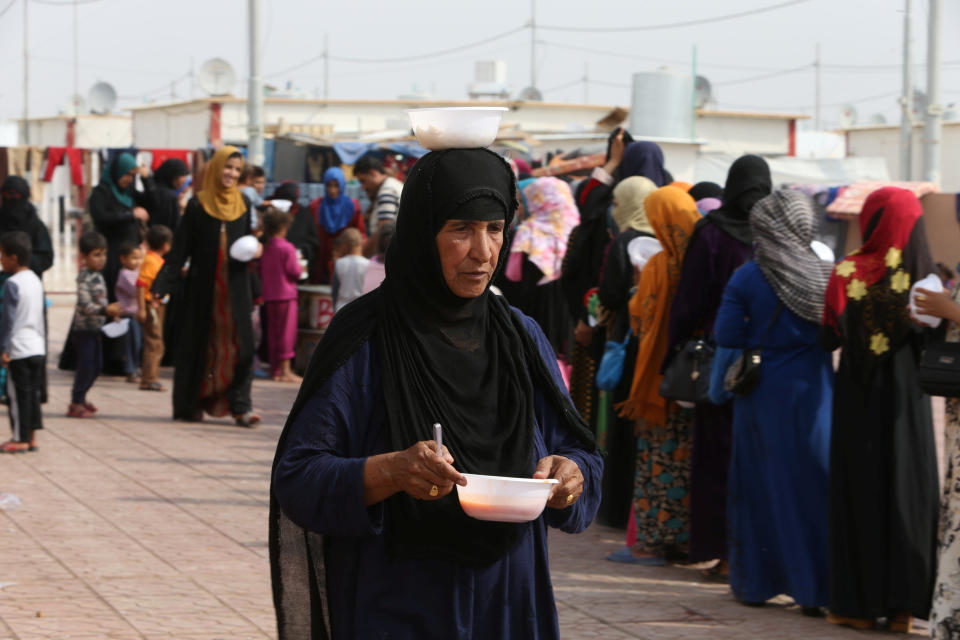 A woman who recently fled the Islamic State's stronghold on the outskirts of Mosul holds a meal after receiving food at a school in Debaga camp, on the outskirts of Erbil, Iraq October 28, 2016. REUTERS/Alaa Al-Marjani