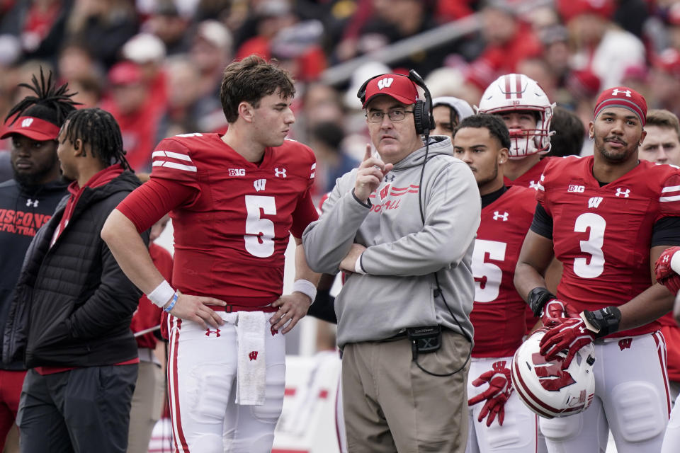 Wisconsin quarterback Graham Mertz (5) and head coach Paul Chryst talk during the first half of an NCAA college football game against Iowa Saturday, Oct. 30, 2021, in Madison, Wis. Wisconsin upset Iowa 27-7. (AP Photo/Andy Manis)