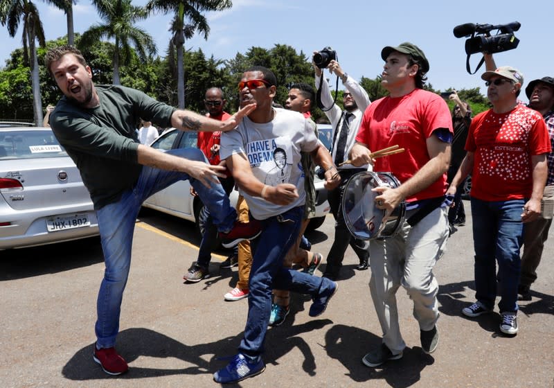 A supporter of Venezuela's President Nicolas Maduro fights with an opposition leader Juan Guaido's supporter outside Venezuelan embassy in Brasilia