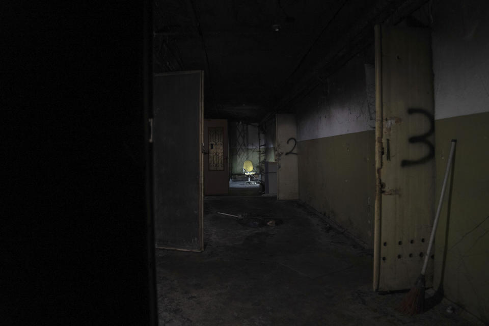 A chair is seen down the hallway of a building which Ukrainian civilians said had been used as a torture center by Russian forces in Kherson, Ukraine, Thursday, Dec. 8, 2022. Civilians said they were detained and tortured at the site when the area was occupied, and many described being tortured while being strapped to office chairs. (AP Photo/Evgeniy Maloletka)