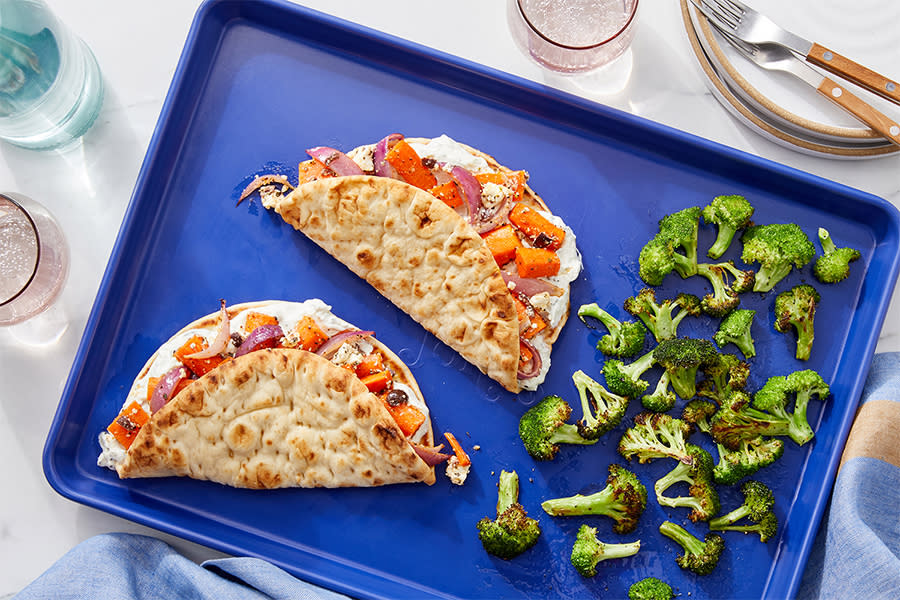 two sandwiches and greens on a blue plate