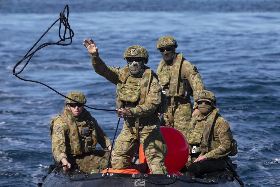 In this Sept. 25, 2020, photo provided by the Royal Australian Navy, members of the Australian Clearance Diving Team One return to Lord Howe Island, Australia, from Elizabeth Reef on a Zodiac inflatable boat following a successful search for unexploded ordnance. The 45-kilogram (100-pound) bomb was found by a fisherman on Elizabeth Reef near Lord Howe Island, about 550 kilometers (340 miles) off New South Wales state. (ABIS Sittichai Sakonpoonpol/Royal Australian Navy via AP)