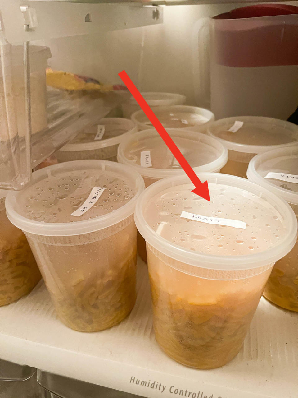 Arrow pointing to the author's fridge full of mac 'n' cheese in individual plastic containers