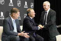 NHL Commissioner Gary Bettman, center, shakes hands with IIHF president Luc Tardif, right, as NHLPA Executive Director Marty Walsh looks on during a news conference in Toronto,Friday Feb. 2, 2024. NHL players are returning to the Olympics for the first time in more than a decade. The world's top hockey league will allow its players to participate in the Games in 2026 in Milan and in 2030 under an agreement announced Friday by the NHL, the NHL Players’ Association, International Ice Hockey Federation and the IOC. (Frank Gunn/The Canadian Press via AP)