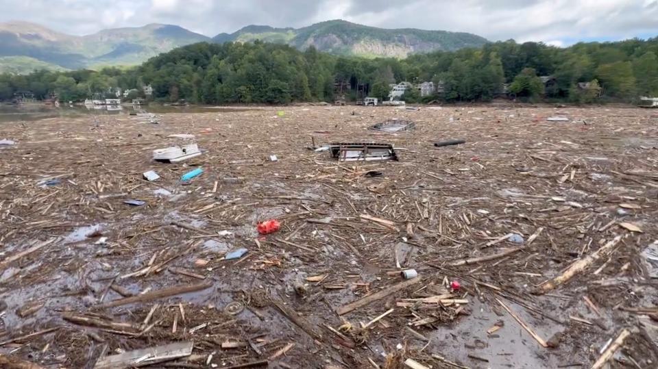 Debris floats in Lake Lure, North Carolina, which a councilman describe as a ‘post-apocalyptic’ wasteland (via REUTERS)