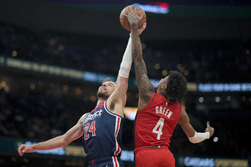 Washington Wizards forward Corey Kispert (24) and Houston Rockets guard Jalen Green (4) reach for a rebound during the first half of an NBA basketball game, Sunday, April 9, 2023, in Washington. (AP Photo/Jess Rapfogel)