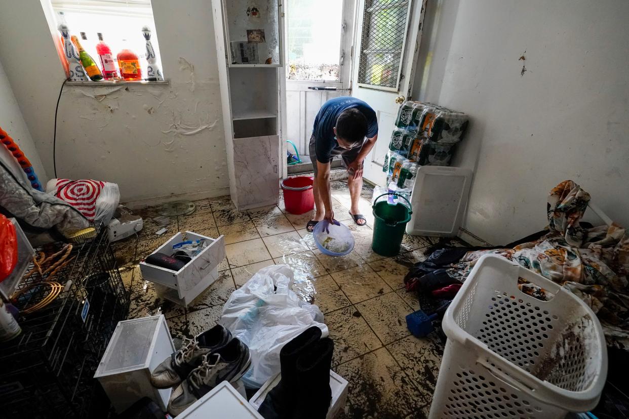 A resident of Peck Ave in the Flushing neighborhood of the Queens borough of New York use buckets to remove water from their basement apartment, Thursday, Sept. 2, 2021, in New York.