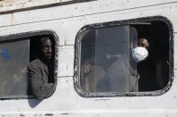 Travelers, some wearing a protective mask, take a bus from the Colobane Bus Station in Dakar, Senegal, Tuesday March 24, 2020. The transport Ministry has announced a limit to the number of passengers in the bus to prevent the risk of contamination by the Coronavirus. The highly contagious COVID-19 coronavirus can cause mild symptoms, but for some it can cause severe illness including pneumonia that may force admission to hospital. (AP Photo/Sylvain Cherkaoui)