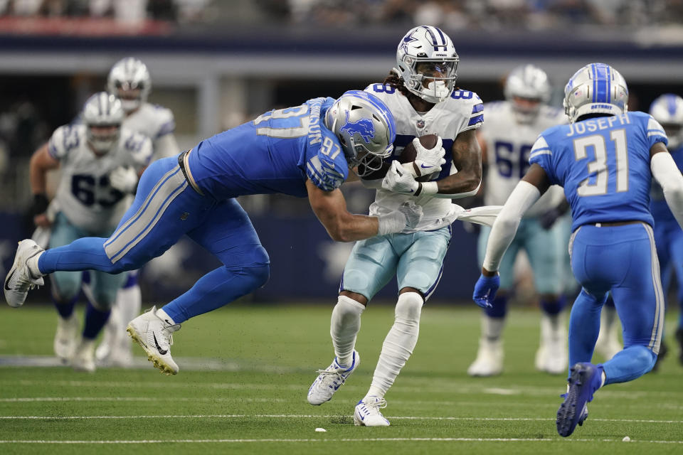 Detroit Lions defensive end Aidan Hutchinson (97) tackles Dallas Cowboys wide receiver CeeDee Lamb (88) during the second half of an NFL football game, Sunday, Oct. 23, 2022, in Arlington, Texas. (AP Photo/Tony Gutierrez)