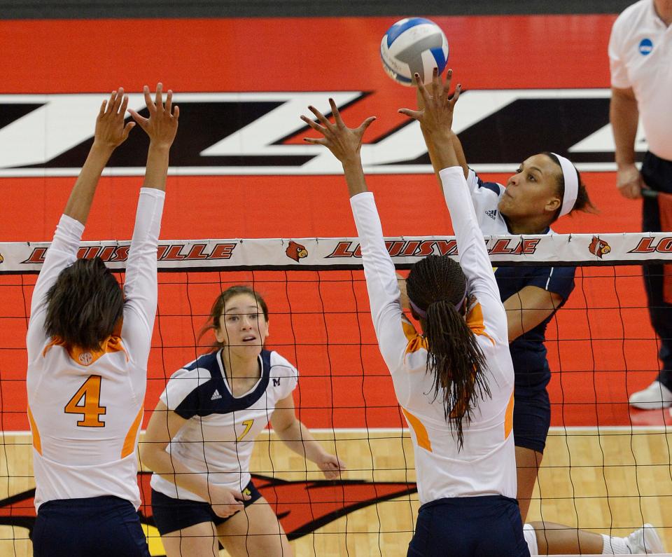 Michigan's Molly Toon, right, attempts to score over the defense of Tennessee's Olivia Okoro, right, and Tiffany Baker during a first round match in the NCAA Division 1 women's college volleyball tournament, Thursday, Nov. 29, 2012, in Louisville, Ky.