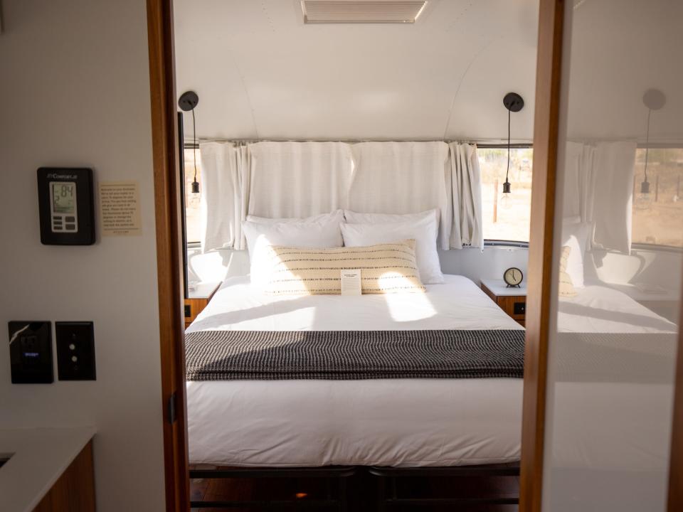 Autocamp Joshua Tree's Airsteram trailer with a view of the bedroom and bed.