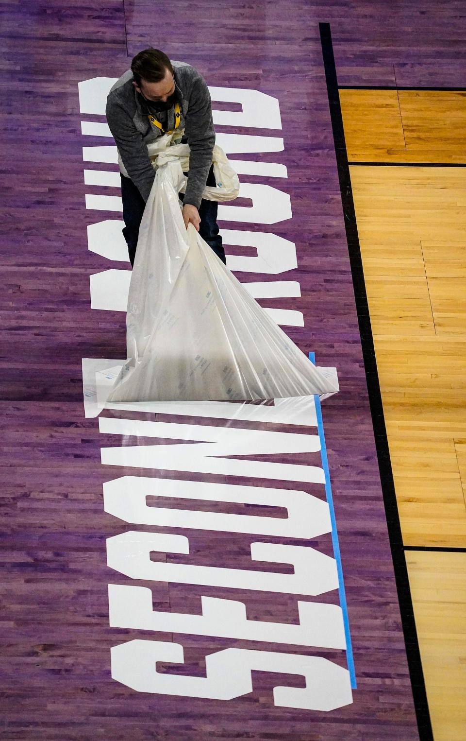 The second-round graphics are placed on the court after the end of the first rounds of the NCAA March Madness basketball games, Saturday, March 20, 2021, at the Indiana Farmer's Coliseum.