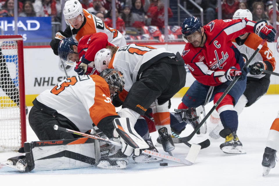 Philadelphia Flyers goaltender Samuel Ersson (33) and defenseman Marc Staal (18) defend as Washington Capitals left wing Alex Ovechkin (8) tries to get the puck during the first period of an NHL hockey game Friday, March 1, 2024, in Washington. (AP Photo/Manuel Balce Ceneta)