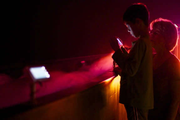 A child uses a cell phone to see infrared "lightning" in Dan Goods's "Beneath the Surface" installation. The piece simulated the environment that the Juno spacecraft might go through as it explores the atmosphere of Jupiter.