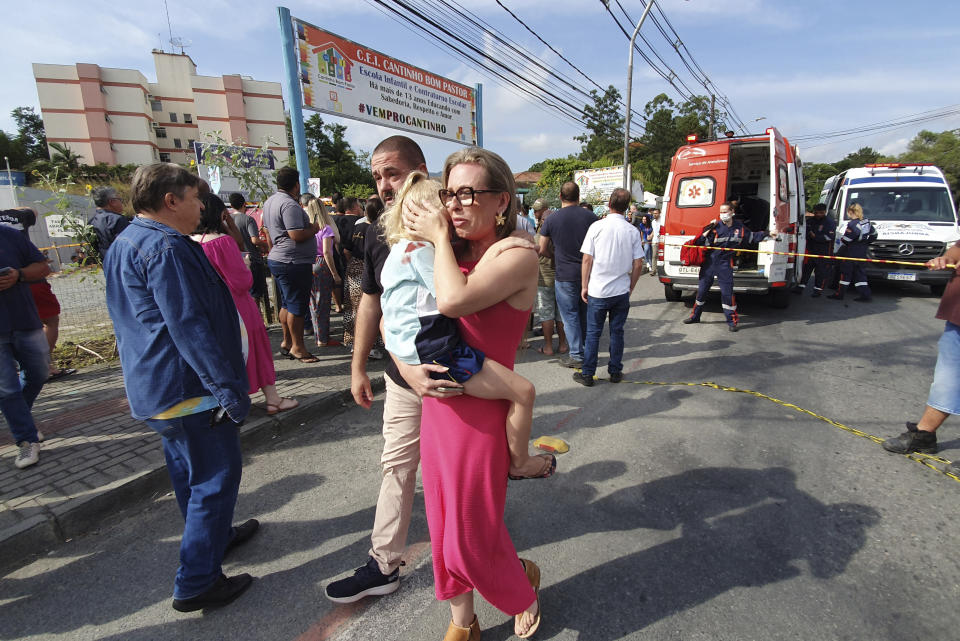 Una mujer reconforta a una niña que llora frente a la guardería Cantinho do Bom Pastor tras un ataque fatal a niños en Blumenau, estado de Santa Catarina, Brasil, miércoles 5 de abril de 2023. (Patrick Rodrigues/Portal NSC Total via AP)