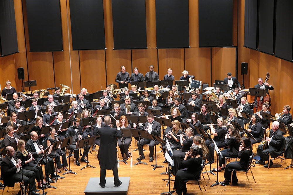 The First Coast Wind Symphony is shown in performance.