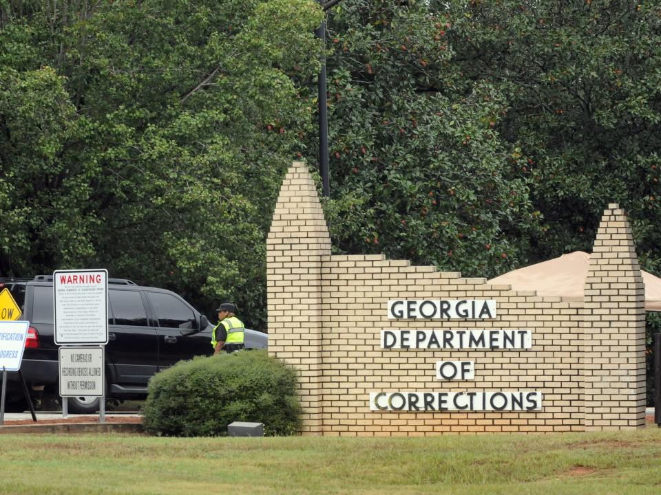 Officers with the Georgia Department of Corrections check a vehicle at the entrance to the Georgia Diagnostic and Classification Prison in Jackson, Georgia.