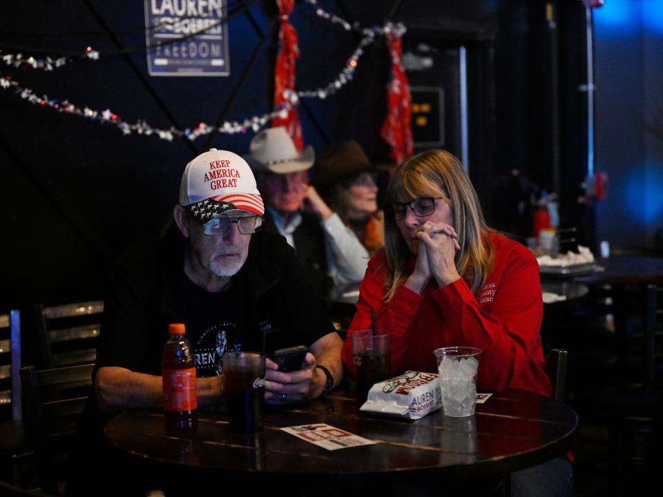 Dale and Sherri VanPelt check their phone for election results during a party for Republican Congresswoman Lauren Boebert on Election night at Warehouse 2565 on November 8, 2022 in Grand Junction, Colorado. Boebert is running against Adam Frisch of the Democratic Party to try for her second term as U.S. representative for Colorado's 3rd congressional district.
