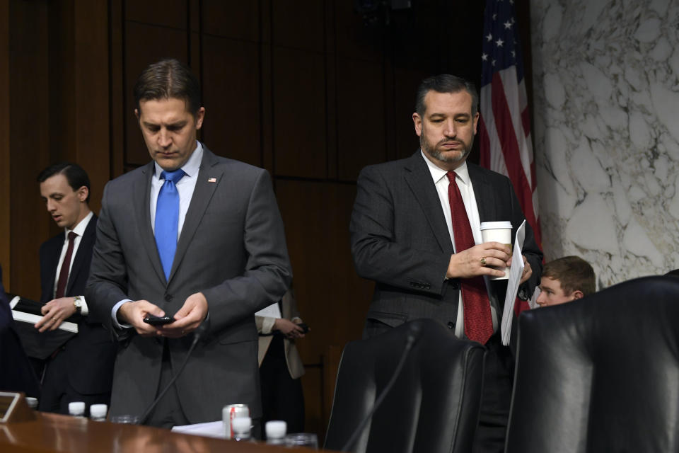 Sen. Ted Cruz, R-Texas, right, arrives for a Senate Judiciary Committee hearing on Capitol Hill in Washington, Wednesday, Dec. 11, 2019, to look at the Inspector General's report on alleged abuses of the Foreign Intelligence Surveillance Act. Sen. Ben Sasse, R-Neb., looks at his phone at left. (AP Photo/Susan Walsh)