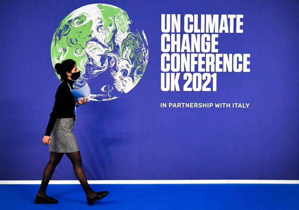 A participant walks past a Conference of the Parties (COP26) U.N. Climate Change Conference's poster on the conference's first day at the Scottish Event Campus (SEC) in Glasgow, Scotland, on October 31, 2021. (Alain Jocard/AFP via Getty Images)