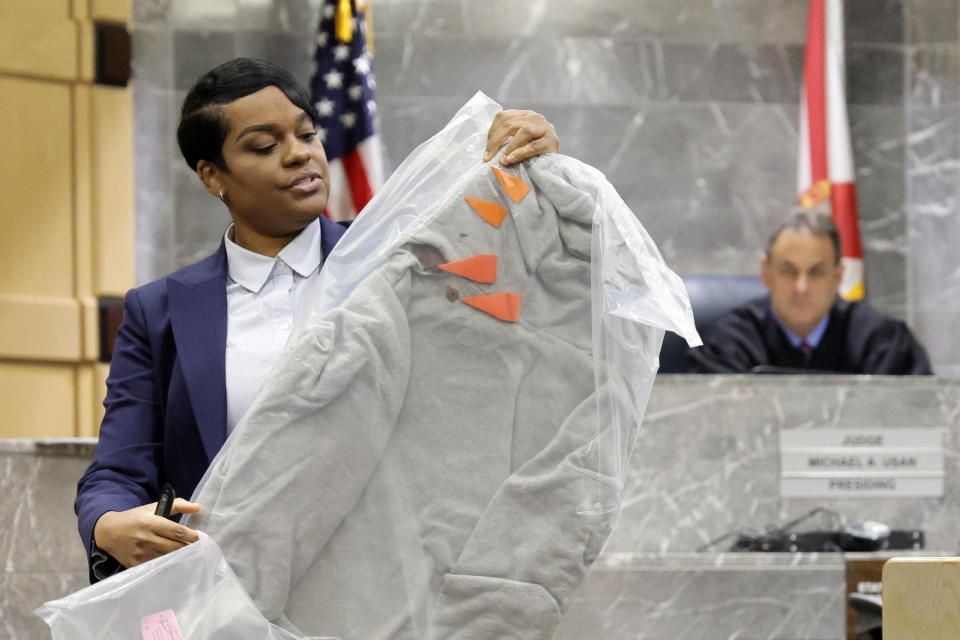 During her closing arguments in the XXXTentacion murder trial, Assistant State Attorney Pascale Achille holds up the sweatshirt worn by the victim at the time of his murder showing orange markers noting bullet holes, at the Broward County Courthouse in Fort Lauderdale, Fla., Tuesday, March 7, 2023. Emerging rapper XXXTentacion, born Jahseh Onfroy, 20, was killed during a robbery outside of Riva Motorsports in Pompano Beach in 2018, allegedly by defendants Michael Boatwright, Trayvon Newsome, and Dedrick Williams. (Amy Beth Bennett/South Florida Sun-Sentinel via AP, Pool)