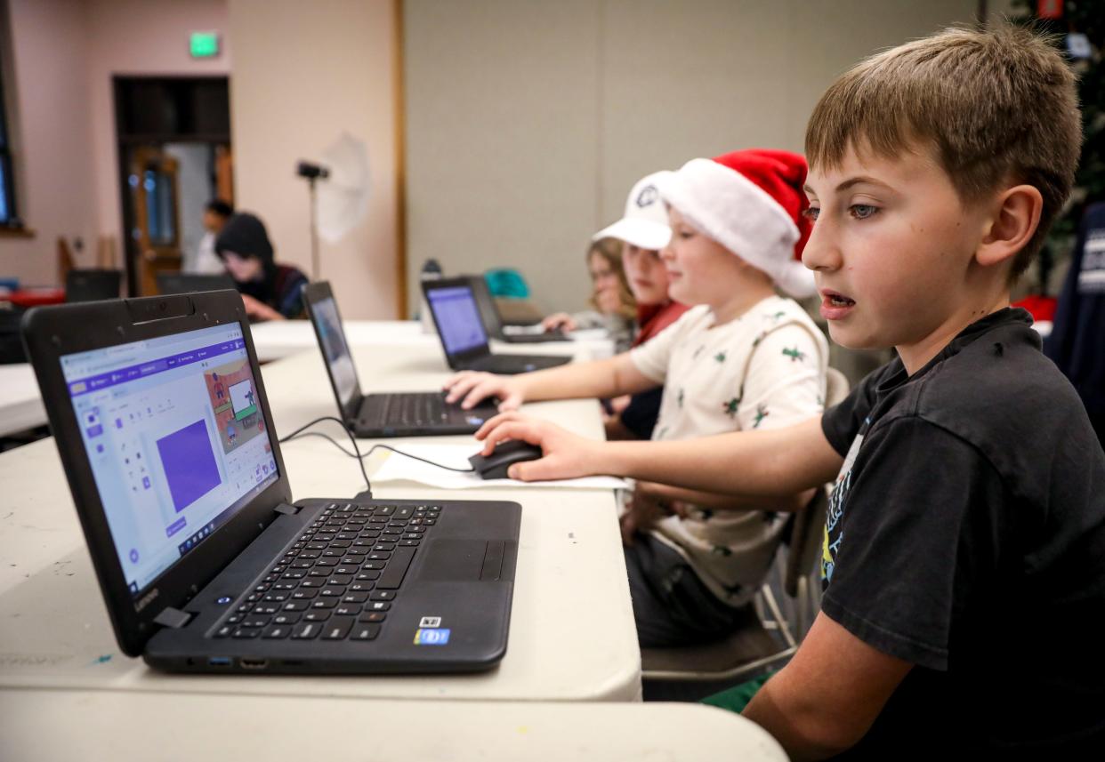 Marshall Martell, 10, works on his computer with his fellow youth coders at Independence Public Library on Dec. 11.