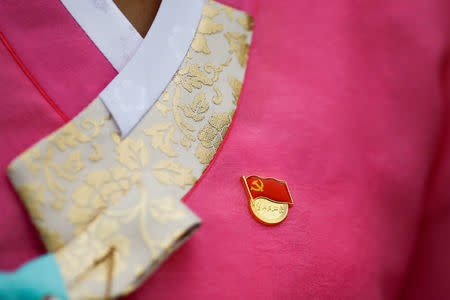 A delegate wears the pin of the Communist Party of China as she leaves the Great Hall of the People in Beijing, one day before the start of 19th National Congress of the Communist Party of China, October 17, 2017. REUTERS/Thomas Peter
