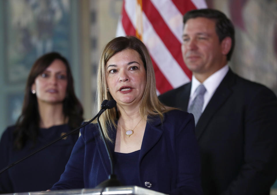 Barbara Lagoa, Governor Ron DeSantis' pick for the Florida Supreme Court, speaks after being introduced, Wednesday, Jan. 9, 2019, in Miami. At rear right is Gov. Ron DeSantis and at left lieutenant governor Jeanette Nunez. (AP Photo/Wilfredo Lee)