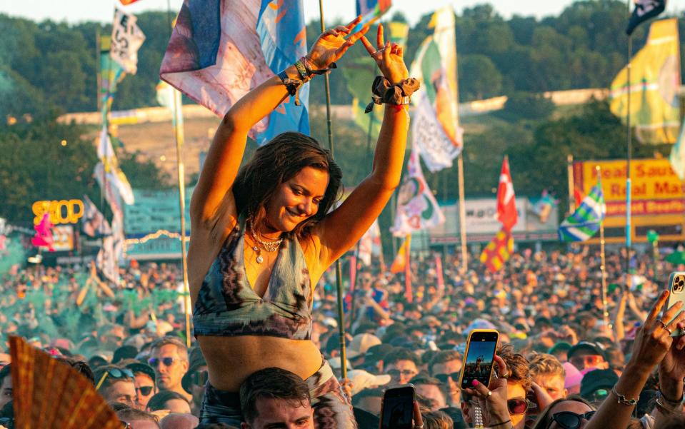 A woman watches Fred Again at Glastonbury Festival in June 2023