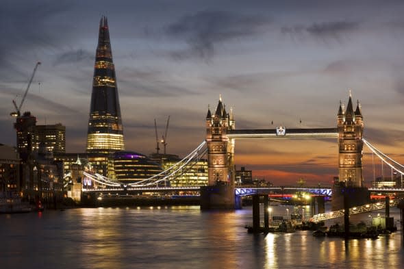 The London skyline at night with the Shard and the London Bridge.