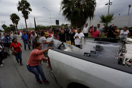 Relatives of inmates grab police shields from a truck arriving at Cadereyta state prison after a riot broke out at the prison, in Cadereyta Jimenez, on the outskirts of Monterrey, Mexico October 10, 2017. REUTERS/Daniel Becerril