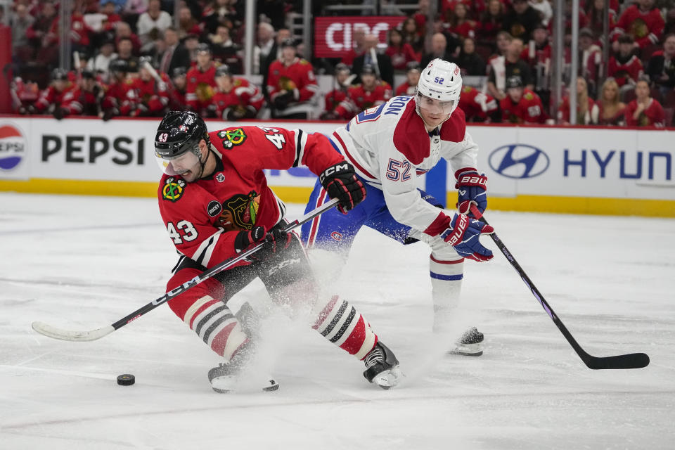 Chicago Blackhawks center Colin Blackwell, left, skates the puck by Montreal Canadiens defenseman Justin Barron during the second period of an NHL hockey game Friday, Dec. 22, 2023, in Chicago. (AP Photo/Erin Hooley)