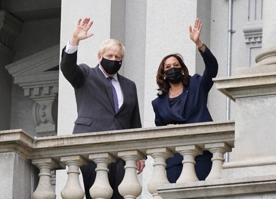 Boris Johnson and vice president Kamala Harris wave from a balcony of the Eisenhower Executive Office Building (Stefan Rousseau/PA) (PA Wire)