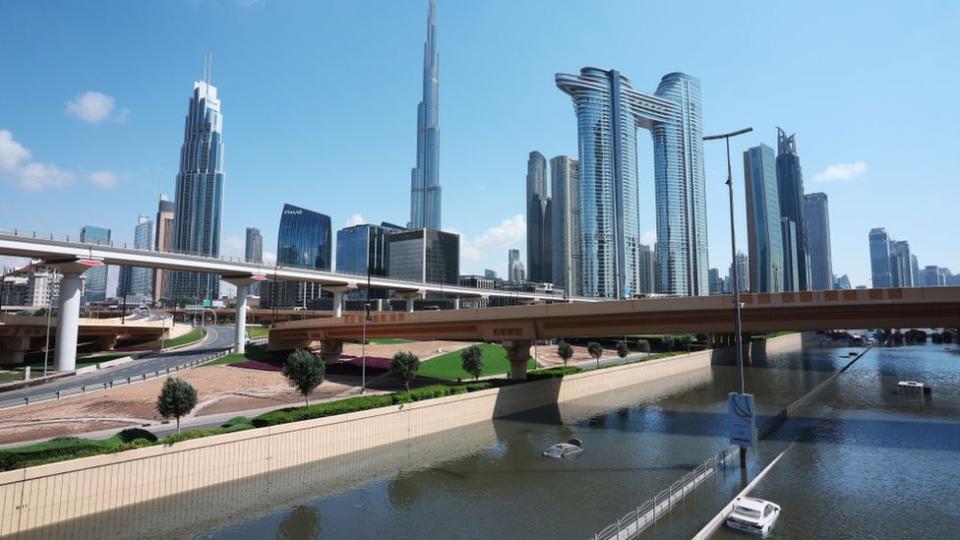 A flooded road and Dubai skyline