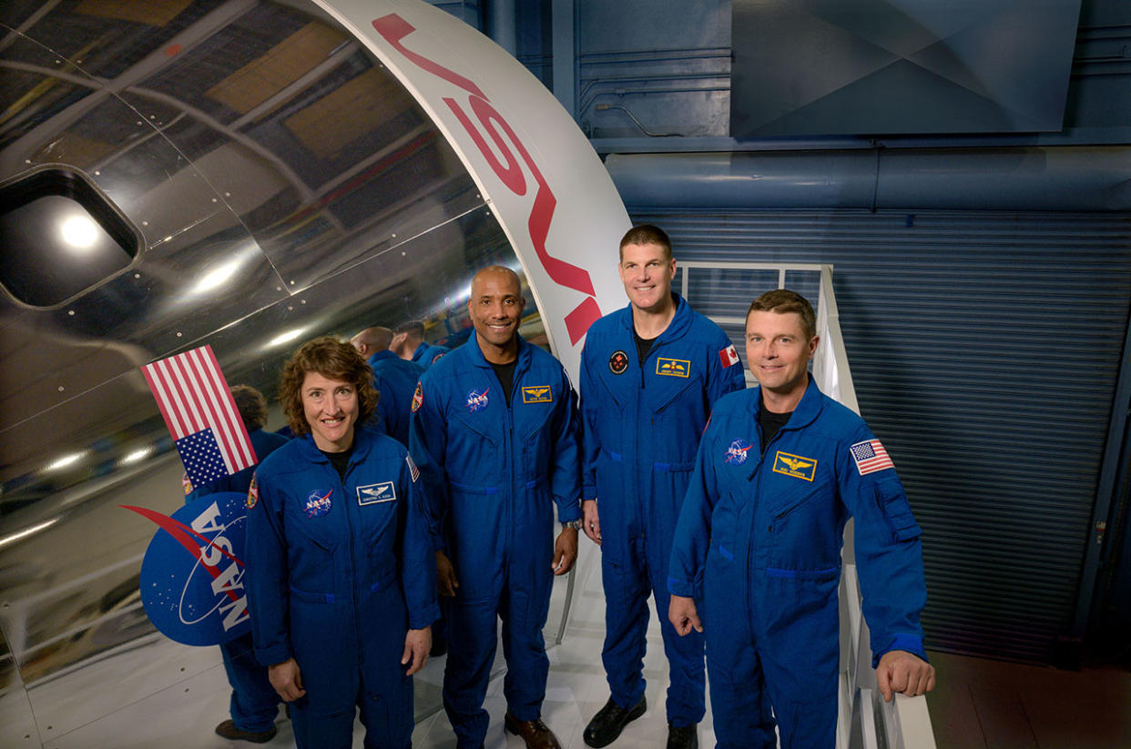  Artemis II crew members (from left) Christina Koch, Victor Glover, Jeremy Hansen and Reid Wiseman pose by an Orion spacecraft simulator at NASA's Johnson Space Center. 