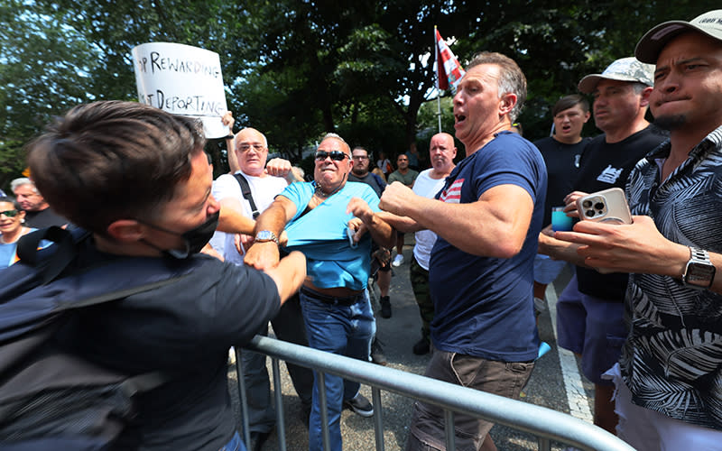 A counter protester gets into a physical confrontation with an anti-migrant protesters