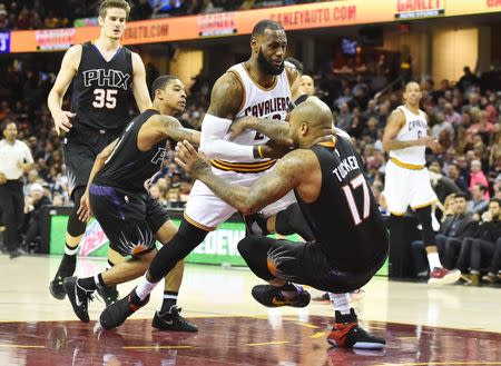 Jan 19, 2017; Cleveland, OH, USA; Cleveland Cavaliers forward LeBron James (23) makes an offensive foul against Phoenix Suns forward P.J. Tucker (17) during the first half at Quicken Loans Arena. Mandatory Credit: Ken Blaze-USA TODAY Sports