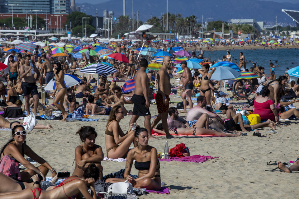 People enjoy the beach in Barcelona, Spain, Saturday, July 18, 2020. Police in Barcelona are closing access to a large area of the city's beaches due to the excess of sunbathers who decided to ignore the urgings of authorities to stay at home amid a resurgence of the coronavirus. (AP Photo/Emilio Morenatti)