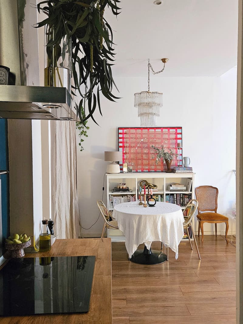 A circular dining table with wooden chair across from kitchen.