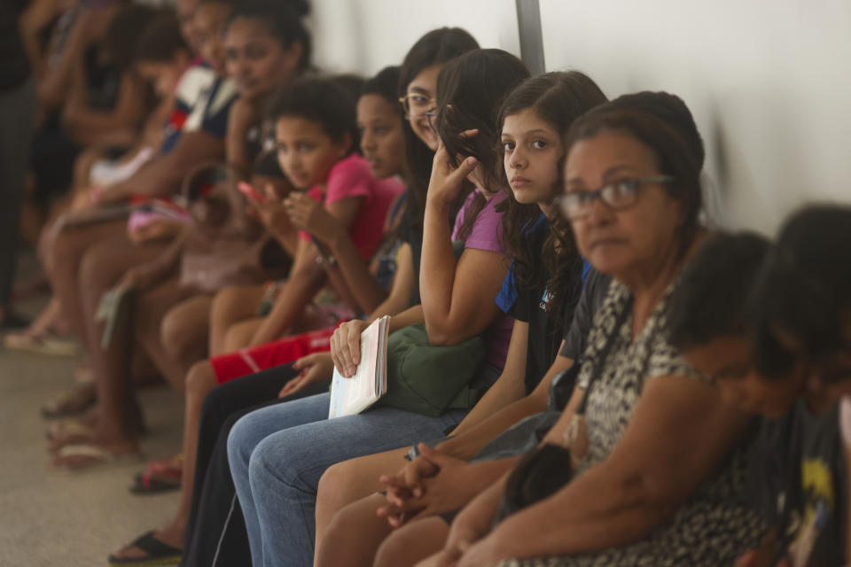 Children wait for dengue vaccines at a health center in the Ceilandia neighborhood on the outskirts of Brasilia, Brazil, Friday, Feb. 9, 2024. The vaccine is available only for children between 10 and 14 years old. (AP Photo/Luis Nova)