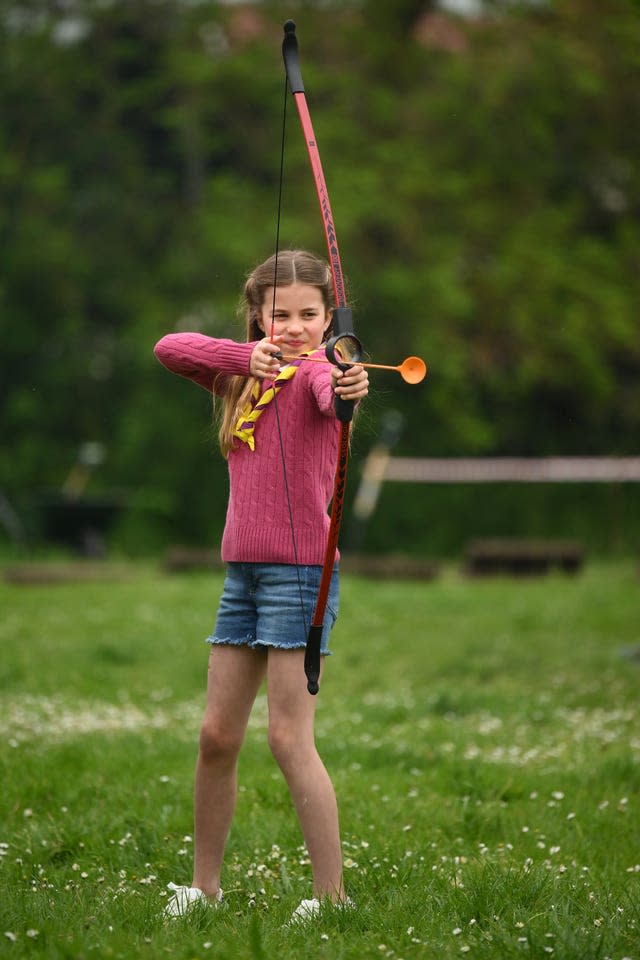 Princess Charlotte tries archery while joining volunteers to help renovate and improve the 3rd Upton Scouts Hut in Slough 