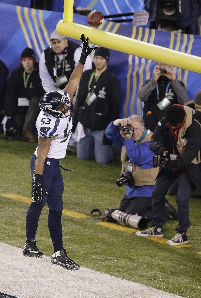 Seattle Seahawks' Malcolm Smith (53) celebrates after returning intercepting a pass for a touchdown during the first half of the NFL Super Bowl XLVIII football game against the Denver Broncos Sunday, Feb. 2, 2014, in East Rutherford, N.J. (AP Photo/Charlie Riedel)