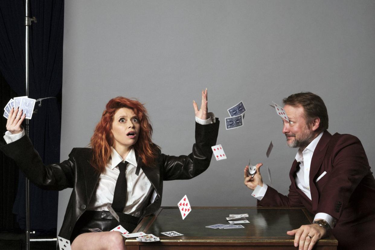 Natasha Lyonne and Rian Johnson throw playing cards in the air for a photo shoot.