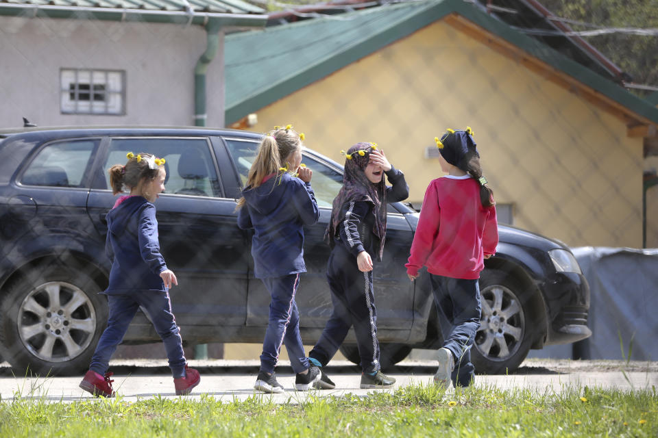 A group of children walk inside a detention center where authorities have brought back from Syria 110 Kosovar citizens, mostly women and children in the village of Vranidol on Sunday, April 20, 2019. Four suspected fighters have been arrested, but other returnees will be cared for, before being sent to homes over the coming days, according to Justice Minister Abelard Tahiri.(AP Photo/Visar Kryeziu)