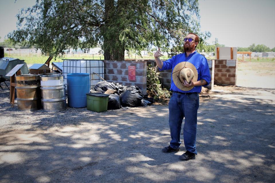 Growing Forward Farm coordinator Andrew Foster introduces farm visitors to the project's composting stations on Friday, July 21 in Aztec.